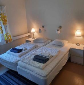a large bed in a bedroom with two lamps at Mäshult Kurs & Lägergård in Skällinge