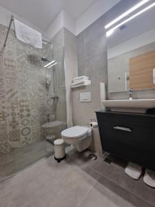 a bathroom with a toilet and a sink and a shower at Vinarija Aleksandrović Rooms in Topola