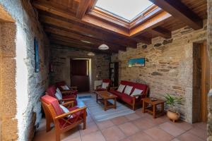 un patio al aire libre con sillas, mesas y tragaluz en Casa rural completa Río Sarela, en Santiago de Compostela