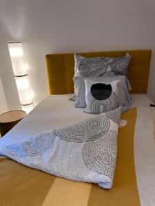 ein Bett mit weißen und grauen Kissen darauf in der Unterkunft Appartement im Geteviertel in Bremen