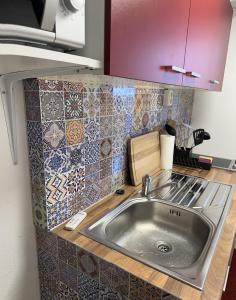 ein Waschbecken in einer Küche mit Wandfliesen in der Unterkunft Appartement im Geteviertel in Bremen
