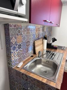 cocina con fregadero y encimera con azulejos en Appartement im Geteviertel, en Bremen