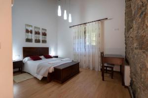 1 dormitorio con cama, mesa y escritorio en Casa rural completa Río Sarela en Santiago de Compostela