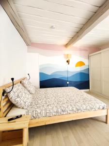 a bedroom with a bed with a painting on the wall at Grand Studio & Terrasse Privée in Hyères