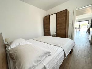 ein weißes Schlafzimmer mit einem großen Bett mit weißer Bettwäsche in der Unterkunft Katarina in Primošten