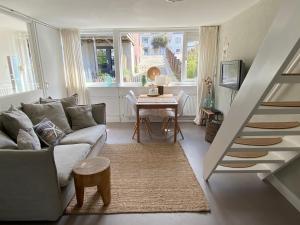 a living room with a couch and a table at Zilt Noordwijk in Noordwijk aan Zee