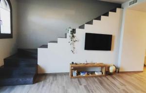 a living room with a staircase and a tv at La Mocina casa vacanze in Castellaro
