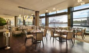 a restaurant with tables and chairs and a view of the sydney at Park Hyatt Sydney in Sydney