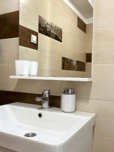 ein Badezimmer mit einem weißen Waschbecken und einem Spiegel in der Unterkunft Katarina in Primošten