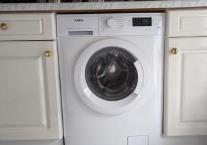 a white washing machine in a kitchen with white cabinets at Penthouse im historischen Fachwerkhaus mit grosser Dachterrasse an zentralster Lage in Boppard