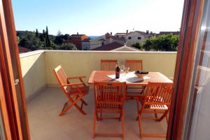 a table and chairs on a balcony with a view at Mata Apartments in Premantura
