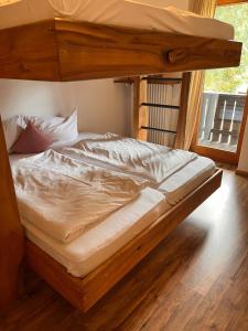 a bedroom with a bunk bed with white sheets at Toni Hütte am Riesserkopf in Garmisch-Partenkirchen