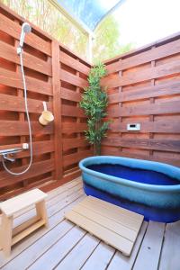 una vasca da bagno su una terrazza con parete in legno di 白浜コンフォートファイブ a Shirahama