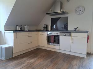 a kitchen with white cabinets and an oven at FeWoMaiFlo in Briedern