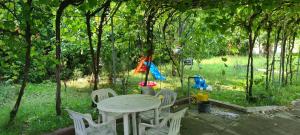 une table et des chaises dans une cour arborée dans l'établissement GM Place apartment 60 m2, à Gornji Milanovac