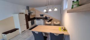 a kitchen with a wooden table and blue chairs at Ferienwohnung Frate in Velden am Wörthersee