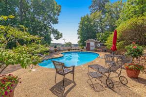 a swimming pool with chairs and a red umbrella at Lake Escape in Hot Springs