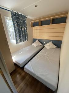 Tempat tidur dalam kamar di Mobile Home Climatisé 6.Personnes
