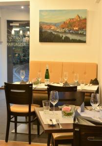 a restaurant with tables and chairs with wine glasses at Linden's Pension-Restaurant in Ayl