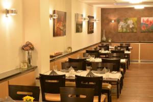 a dining room with tables and chairs in a restaurant at Linden's Pension-Restaurant in Ayl