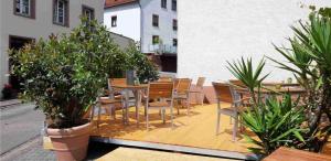 un patio avec des tables, des chaises et des plantes en pot dans l'établissement Linden's Pension-Restaurant, à Ayl
