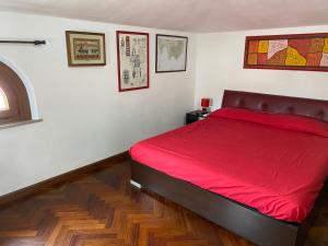 una camera da letto con un letto con una coperta rossa di affitto turistico Lavigna24 a La Maddalena