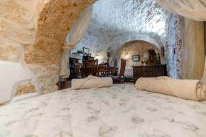 a bedroom with a large bed with a stone wall at Trullo Tranquillo in San Michele Salentino