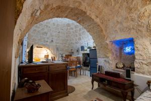 een keuken en een woonkamer met een stenen muur bij Trullo Tranquillo in San Michele Salentino