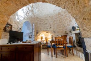 a kitchen and dining room with a stone wall at Trullo Tranquillo in San Michele Salentino