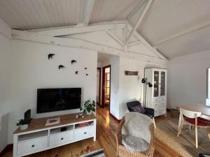 a living room with a television and birds on the wall at Casa da Vila em Celorico de Basto - Growhome in Celorico de Basto