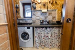 a kitchen with a washing machine and a sink at Trullo Tranquillo in San Michele Salentino +32 photos