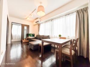un soggiorno con un tavolo e un divano di Z Apart ment 大阪通天閣玩具街旅居 ad Osaka