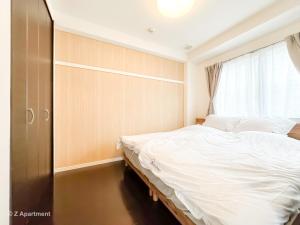 una camera da letto con un letto grande e una finestra di Z Apart ment 大阪通天閣玩具街旅居 ad Osaka
