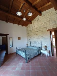 a bedroom with a bed and a stone wall at Agriturismo Torre Gialluise in Gesualdo