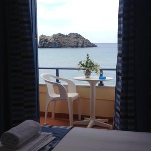 a table and chairs with a view of the ocean at Hotel Kyma in Skala Eresou