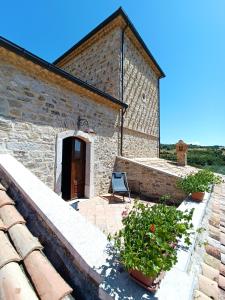 a stone building with a chair on a patio at Agriturismo Torre Gialluise in Gesualdo