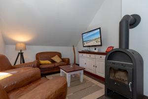 een woonkamer met een houtkachel en een bank bij Ferienwohnung W16 3 S in Graal-Müritz