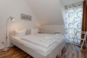 een wit bed in een kamer met een raam bij Ferienwohnung W16 3 S in Graal-Müritz