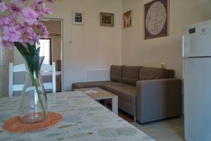a living room with a couch and a vase of flowers on a table at Apartment Ella in Trogir