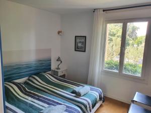 a bedroom with a bed and a window at La Balancelle in Marseille