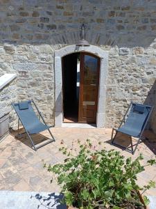 two blue chairs sitting in front of a building at Agriturismo Torre Gialluise in Gesualdo