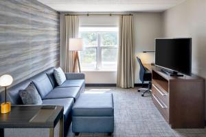 a living room with a couch and a flat screen tv at Residence Inn by Marriott Rochester West Greece in Rochester