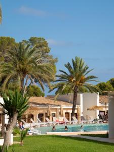 a resort with a swimming pool and palm trees at Hotel Montepiedra 4''''sup in Playas de Orihuela