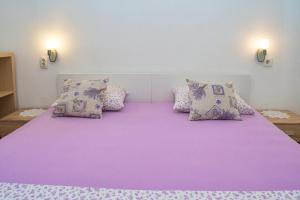 a bedroom with a large purple bed with pillows at Apartment Ella in Trogir