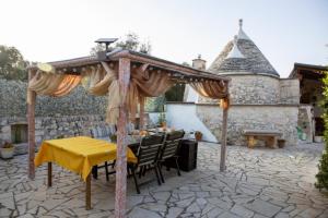 a table and chairs under an umbrella on a patio at Trullo Tranquillo in San Michele Salentino