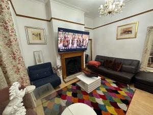 sala de estar con sofá y TV en 4 Double Bed Family Home 15 mins from Central Ldn en Londres