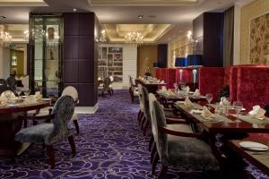 a restaurant with wooden tables and chairs and a purple carpet at Grand Soluxe Hotel Xi'an in Xi'an
