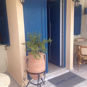 a plant sitting on a chair in front of a door at Hotel Kyma in Skala Eresou