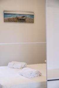 a white bed with two white towels on it at Isola Bella Luxury View in Taormina