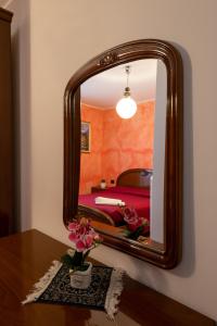 a mirror on a wall next to a bedroom at Albergo San Michele in Tirano